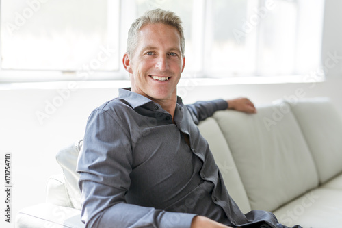 Fotografie, Obraz Portrait of single 40s man sitting in sofa