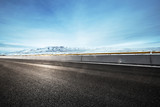 Fototapeta Na sufit - empty asphalt road with snow mountains in blue sky
