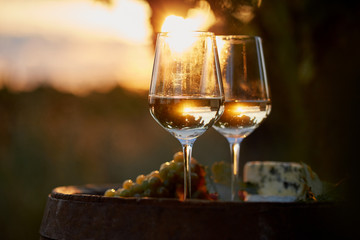 Two glasses of white wine with food at sunset