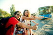 © dusanpetkovic1 - Group of smiling tourist waiting for a bus on the street.