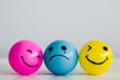 Emotions balls: Happy smiley face pink and yellow ball and depress sadness ball crying in the middle, concept: Why are you so sad?