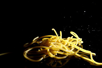 Pasta background / Spaghetti is a long, thin, cylindrical, solid pasta. It is a staple food of traditional Italian cuisine. Like other pasta, spaghetti is made of milled wheat and water.