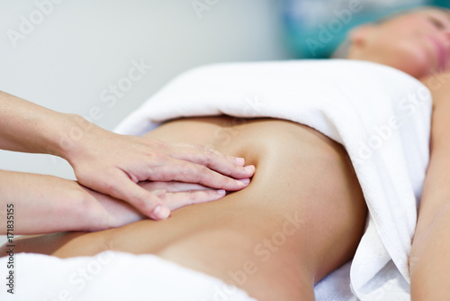 Zdjęcie XXL Ręki masuje żeńskiego podbrzusze. Terapeuta stosuje nacisk na brzuchu.
