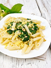 Wall Mural - Pasta penne with spinach and cedar nuts on light board