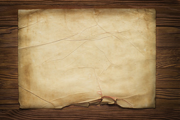 Canvas Print - old broken horizontal sheet of paper on brown wooden board