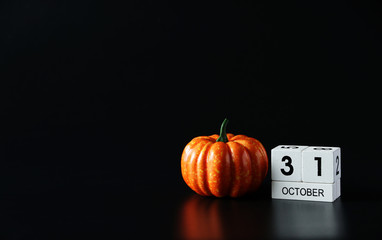 31 October Wooden calendar and pumpkin for Halloween day on background.Copy space,minimal style