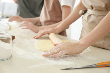 Family preparing dough together in kitchen. Cooking classes concept