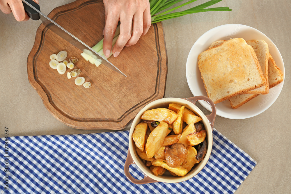 Woman preparing tasty dinner on table in kitchen. Cooking for one concept