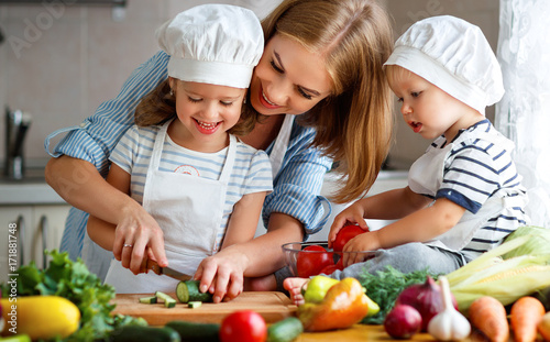 Plakat Zdrowe odżywianie. Szczęśliwa rodziny matka i dzieci przygotowywamy jarzynowej sałatki w kuchni.