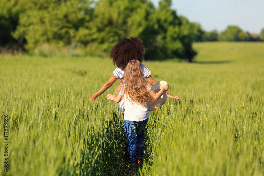 Happy little girls in green field