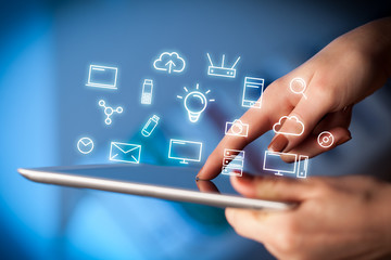 fingers touching tablet with icons