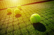 Tennis balls on grass court with sunlight