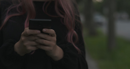 Wall Mural - female teen using smartphone on the street at night