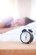 © lenets_tan - Young sleeping woman and alarm clock in bedroom at home. Young sleeping woman.