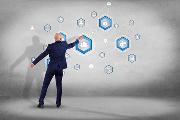 Poster - businessman in front of a wall with a business network connection displayed on a futuristic interfac