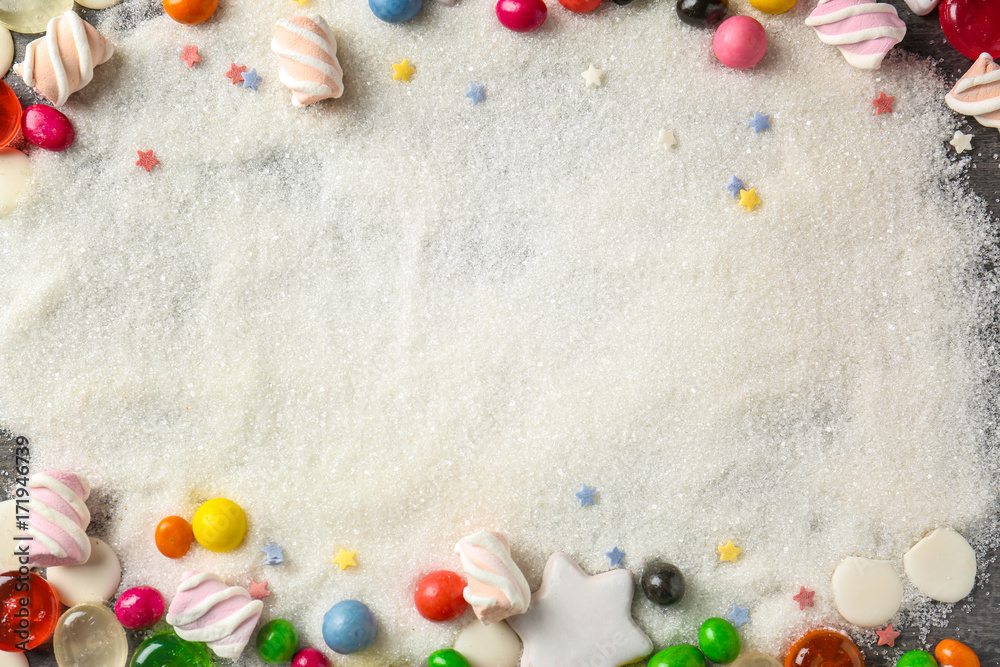Frame made of colorful candies on sugar background