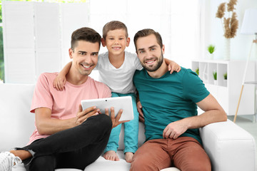 Wall Mural - Male gay couple with foster son resting at home. Adoption concept