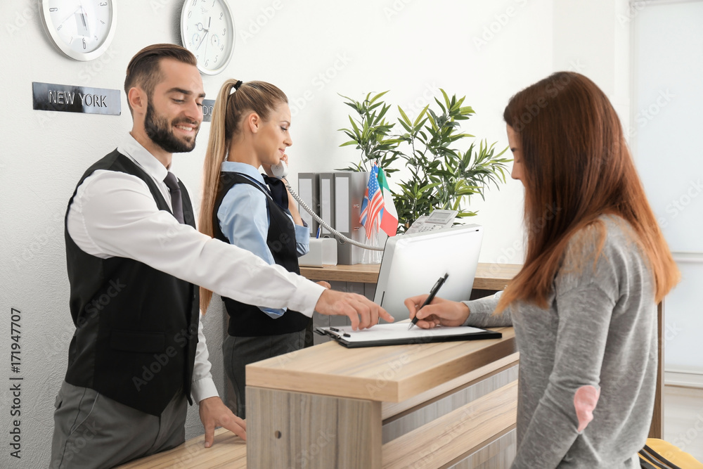 Young woman near reception desk in hotel