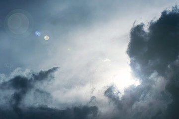 Wall Mural - the sun makes its way through the dark storm clouds.