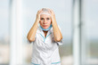 © DenisProduction.com - Surprised and confused female doctor. Portrait of white-skin female doctor or nurse surprised starring with scared eyes, blurred background.