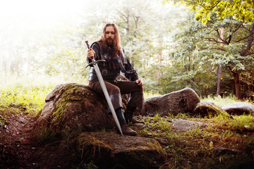 Knight on the road. A guy in a medieval costume with a sword