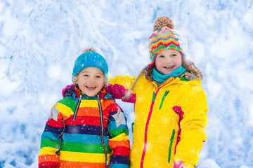 Kids play with snow in winter park