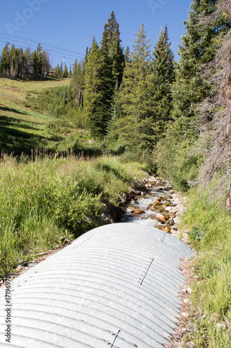 Valokuva Stream through a metal corrugated culvert in Colorado