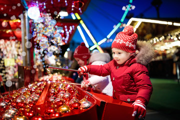 Wall Mural - Kids at Christmas fair. Children shopping xmas gifts.