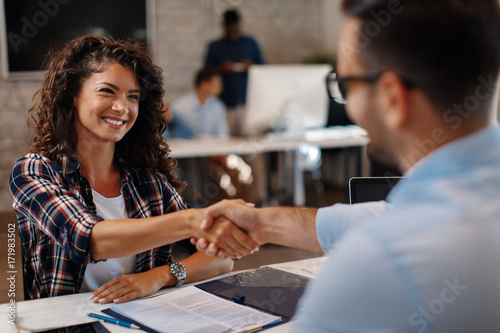 Fotografía Young woman signing contracts and handshake with a manager