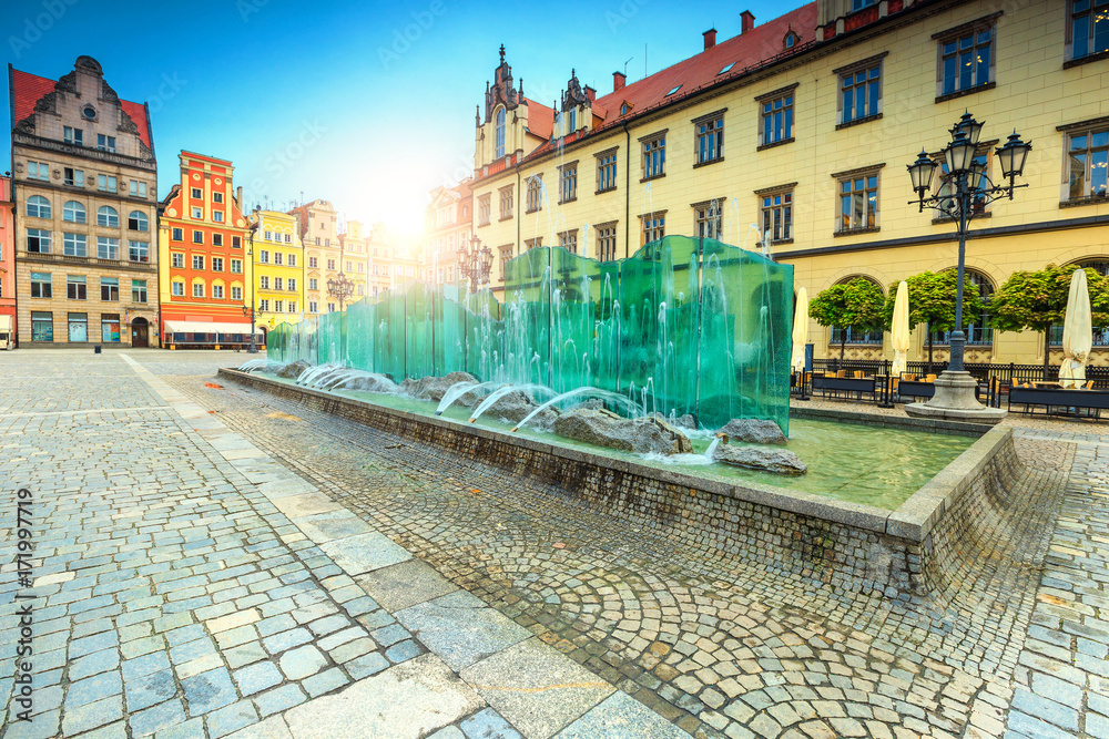 Spectacular glass fountain in square with colorful houses, Wroclaw, Poland - obrazy, fototapety, plakaty 
