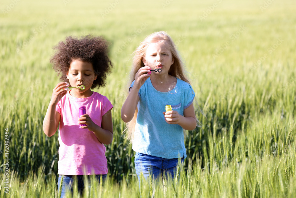 Happy little girls in green field