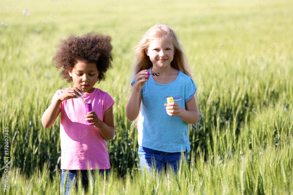 Happy little girls in green field