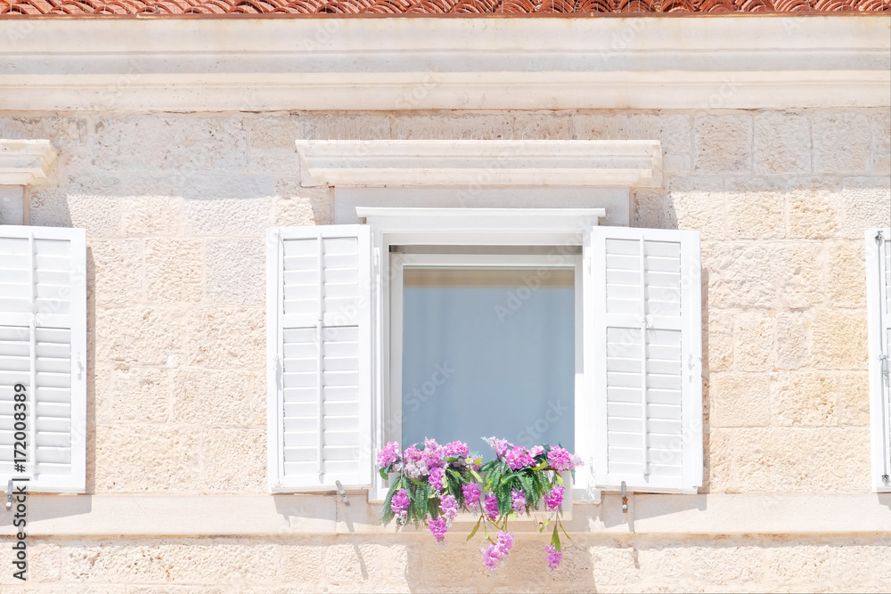 View of stone house with flowers on window