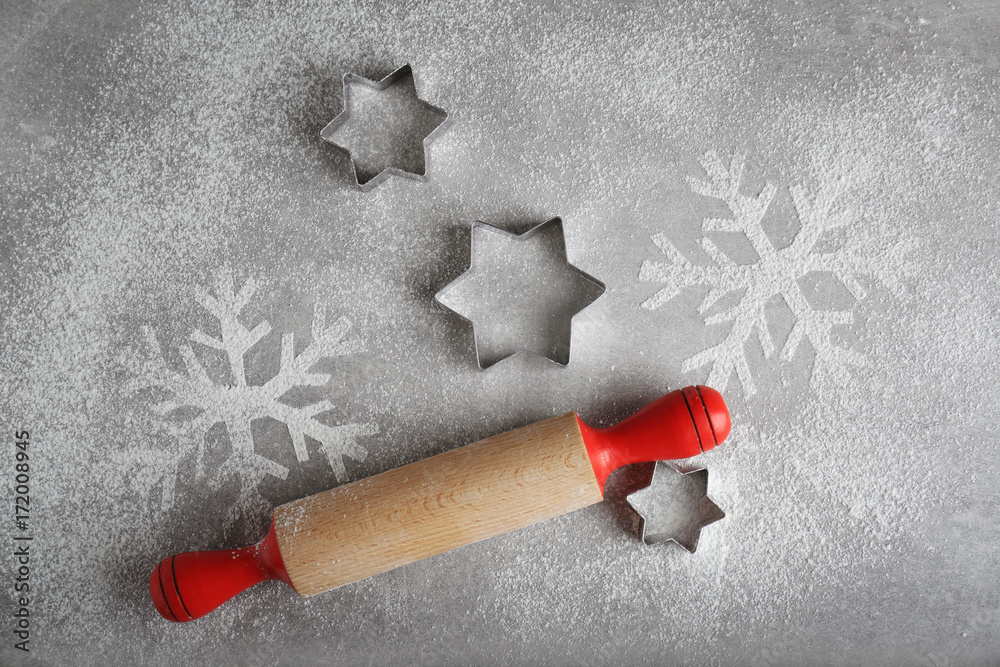 Christmas composition with rolling pin and snowflakes on grey background