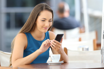 Sticker - Happy girl checking a smart phone in a bar