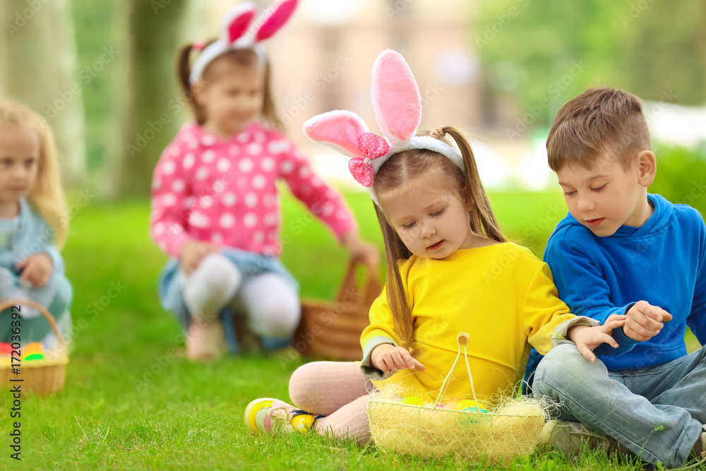 Children having fun in park. Easter egg hunt concept
