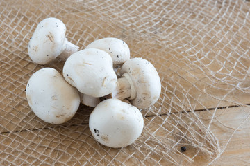 Wall Mural - Overhead view of mushrooms champignon on natural, wooden board 