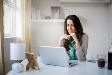 Caucasian freelancer working on laptop at home office