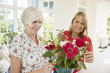 © Monkey Business - Senior woman and adult daughter arranging flowers at home