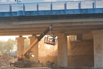 Under the bridge. Structure and architecture of the bridge in perspective, illuminated by sun