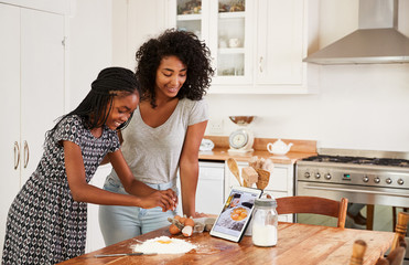 Wall Mural - Teenage Girls Following Recipe On Digital Tablet