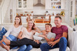 © Monkey Business - Family With Teenage Children Sitting On Sofa Watching TV Together