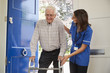 © Monkey Business - Nurse helps senior man using walking frame at home, close up