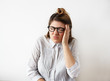 © shurkin_son - Studio shot of funny young woman employee having painful expression because of bad headache or hangover, holding head and grimacing. Emotional female office worker having stressful day at work