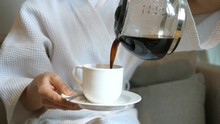 Woman In Bathrobe Pouring Hot Filtered Coffee From Glass Pot. Closeup. 4K. 