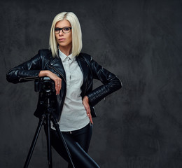 Blond photographer female on a grey background.