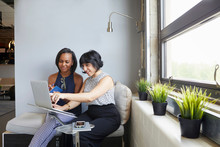 Two Women Sitting, Working On Laptop, On Laptop Stand