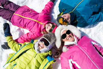 Wall Mural - Smiling family lying on snow