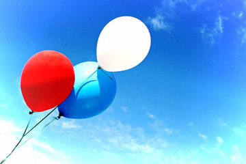 colorful balloons fly agnst a blue sky