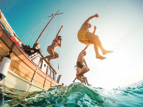 Fotografía Happy friends diving from sailing boat into the sea - Young people jumping insid